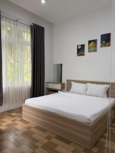 a bedroom with a large bed and a window at Homestay Tulip Garden Bảo Lộc in Bảo Lộc +67 photos