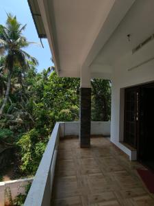 a porch of a house with a palm tree at Ram's Heaven in Guruvāyūr