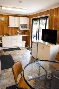 a kitchen with a table and chairs and a tv at Warrack Motel in Warracknabeal