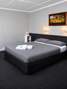 a bed in a room with two towels on it at Warrack Motel in Warracknabeal