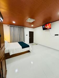 a bedroom with a bed and a tv on the ceiling at Arcadiaa Villa in Polonnaruwa
