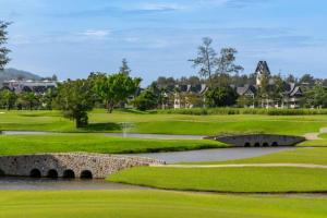 a golf course with a bridge over a river at Modern 2BR Apartment with Golf View in Laguna Phuket - Condo Ozone 108-156 in Laguna Phuket