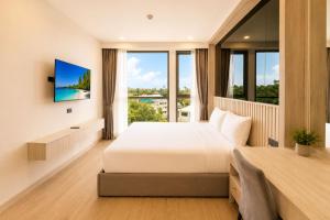 a hotel room with a bed and a large window at Modern 2BR Apartment with Golf View in Laguna Phuket - Condo Ozone 108-156 in Laguna Phuket +16 photos