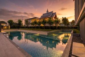a house with a swimming pool in front of a building at Modern 2BR Apartment with Golf View in Laguna Phuket - Condo Ozone 108-156 in Laguna Phuket