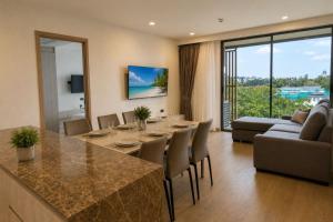 a kitchen and living room with a table and chairs at Modern 2BR Apartment with Golf View in Laguna Phuket - Condo Ozone 108-156 in Laguna Phuket