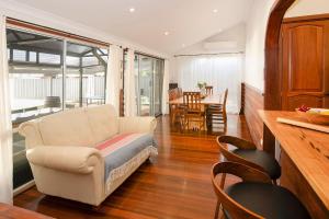 a living room with a couch and a dining room at Busselton Central Accommodation in Busselton