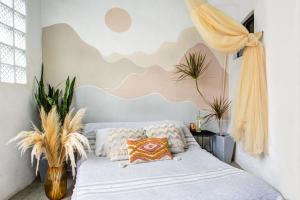 a bedroom with a bed with a cloud mural on the wall at Sayulita Boutique Suites - Pool Access, Kitchen, Walk to Beach in Sayulita
