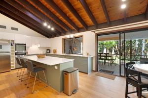 a kitchen with a large island and a table with chairs at Kookaburra Retreat in Berkeley Vale