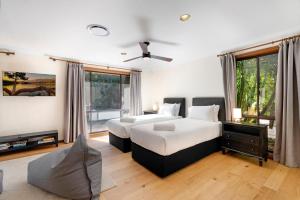 a bedroom with two beds and a flat screen tv at Kookaburra Retreat in Berkeley Vale +33 photos