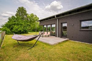 a hammock on a deck next to a house at Ferienwohnung Cleo in Mirow