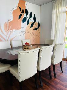 a dining room with a table and white chairs at Corazón garden in Piura