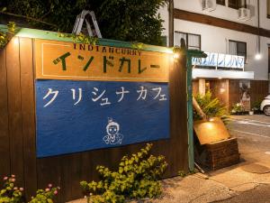 a sign on a wooden fence with a sign for an inn inventory at Hotel shirahama in Shirahama