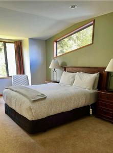 a bedroom with a large bed and a window at The Ferns Hideaway in Franz Josef