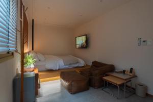 a bedroom with a bed and a couch and a table at Nakwon Stay 3-Min Walk to Anguk & Jongno 3-ga Stations in Seoul +125 photos