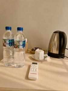 two bottles of water and a remote control on a table at Qwank Kuta Lombok in Kuta Lombok