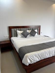 a bedroom with a large bed with white sheets and pillows at Sukhavasam Beach Resort in Adgaon