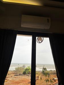 a view of the ocean from a room with a window at Sukhavasam Beach Resort in Adgaon +4 photos