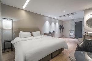 a bedroom with a large white bed and a chair at Bergen Hotel Daejeon Yuseong in Daejeon +80 photos