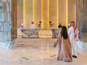 a little girl looking at two priests in a room at Raffles Jeddah in Jeddah +64 photos