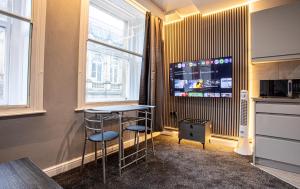 a room with a table and two stools and a tv at The Piece Hall Harmony Designer Studio - Superking in Halifax