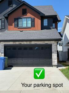 a house with a parking spot in front of a garage at The Onyx Suite Sleek Modern Space Private Entry in Regina
