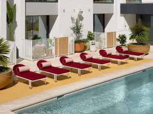 Eine Gruppe roter Liegestühle neben einem Swimmingpool in der Unterkunft Hyde Perth in Perth