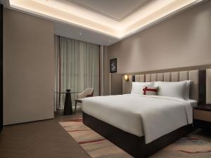 a hotel room with a large bed and a table at Mövenpick by Accor Shanghai People's Square in Shanghai +69 photos