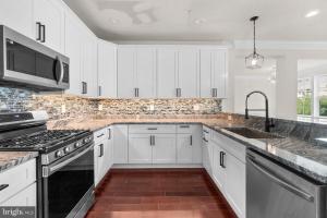a kitchen with white cabinets and a sink at Juway Empire Homes in Reisterstown