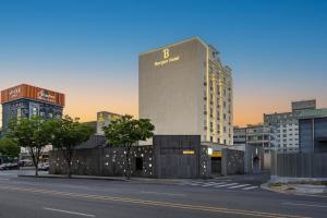a building with a sign on the side of a street at Bergen Hotel Daejeon Yuseong in Daejeon