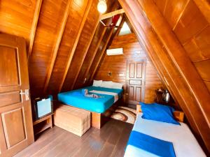 a room with a blue bed in a wooden cabin at That's Why Nilaveli Beach Cabanas in Trincomalee