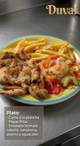 a plate of food with french fries on a table at hostal y centro de eventos in Chorrillos