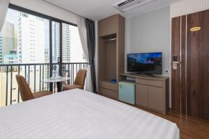 a bedroom with a bed and a balcony with a television at Amora Hotel in Nha Trang