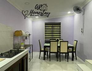 a dining room with a table and chairs in a kitchen at Ar Homestay Merlimau in Merlimau