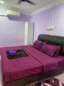 a purple bedroom with a large bed with purple sheets at Ar Homestay Merlimau in Merlimau