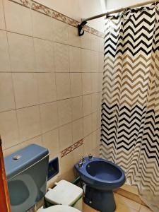 a bathroom with a blue toilet and a shower curtain at Casa Luis del carmen in Fiambalá