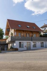 a large white building with a brown roof at Übernachtung beim Bio-Metzger "Zimmer Rosl" in Mössingen