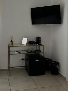 a room with a desk with a television on a wall at Serèsia Rooms Siracusa Centro in Syracuse +2 photos