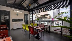a restaurant with a balcony with tables and chairs at Berlin Haus Nha Trang Hotel in Nha Trang