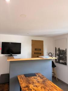a room with a desk with a tv and a table at Gite Climatisé Les Terrasses Perchées 2 Chambres in Saint-Vincent