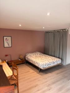 a bedroom with a bed and a table at Gite Climatisé Les Terrasses Perchées 2 Chambres in Saint-Vincent