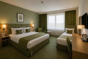 a hotel room with two beds and a desk at Khatai Center Hotel in Baku