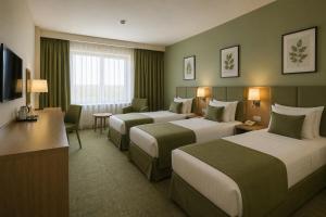 a hotel room with two beds and a television at Khatai Center Hotel in Baku