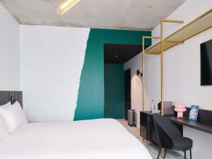 a room with two beds and a desk with a computer at Mercure Quimper Kerlic in Quimper