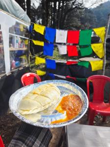a plate of food on a table with a pie at Raghupur trecking camp in Shoja