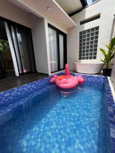 a swimming pool with a red raft in the middle at Defano Villa Klotok in Yogyakarta