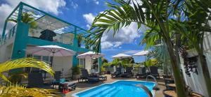 a resort with a pool and chairs and umbrellas at Abiki Mauritius with Tourism Authority Permit in Albion