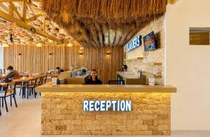 a restaurant with a reception counter and people sitting at tables at Islanders Hostel Siquijor in San Juan