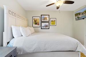 a bedroom with a white bed with a ceiling fan at Crosswinds Near Beach & Shops in Kennebunk