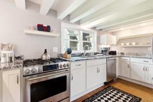a kitchen with white cabinets and a stove top oven at Crosswinds Near Beach & Shops in Kennebunk +30 photos