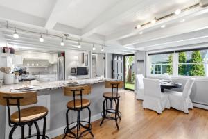 a kitchen with white cabinets and bar stools at Crosswinds Near Beach & Shops in Kennebunk